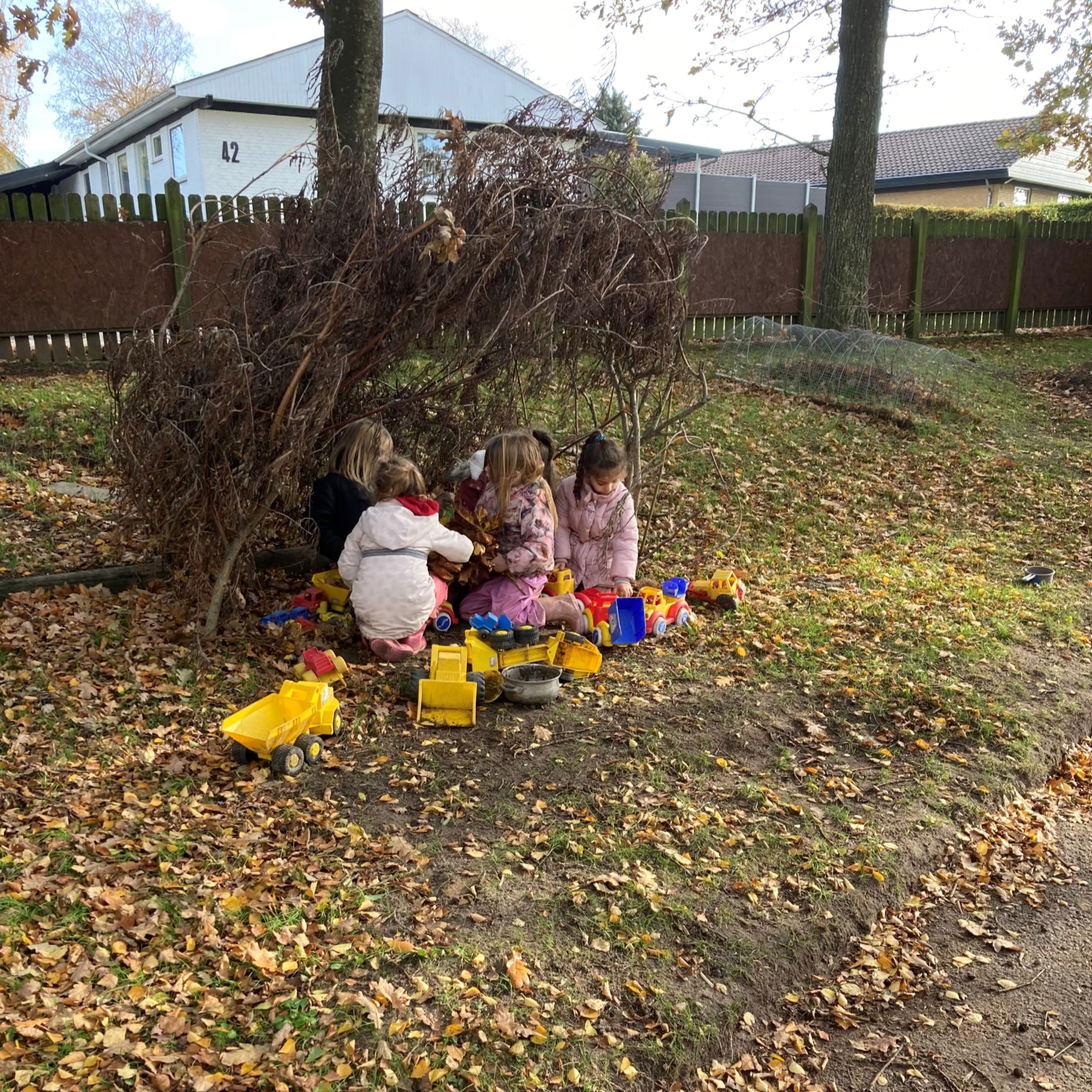 Børnehaven leger ude med plastikbiler i Børnehuset Hørhaven