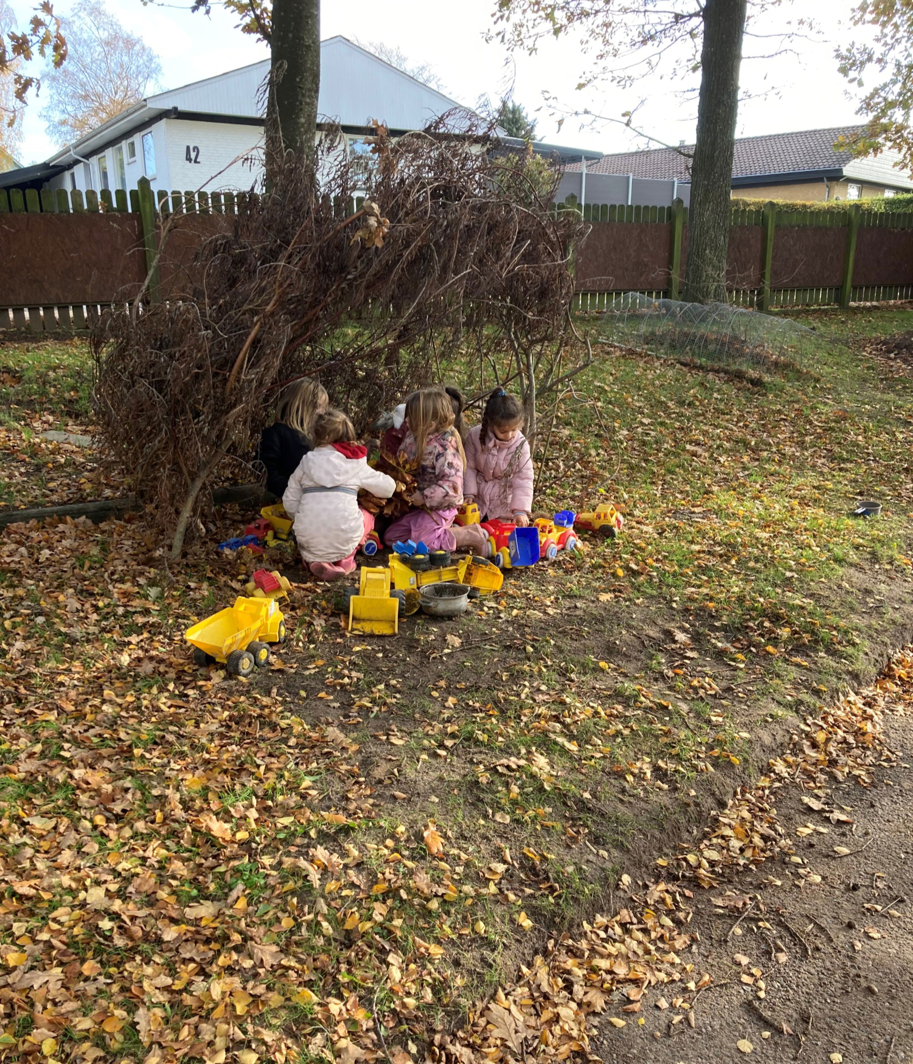 Børnehaven leger ude med plastikbiler i Børnehuset Hørhaven