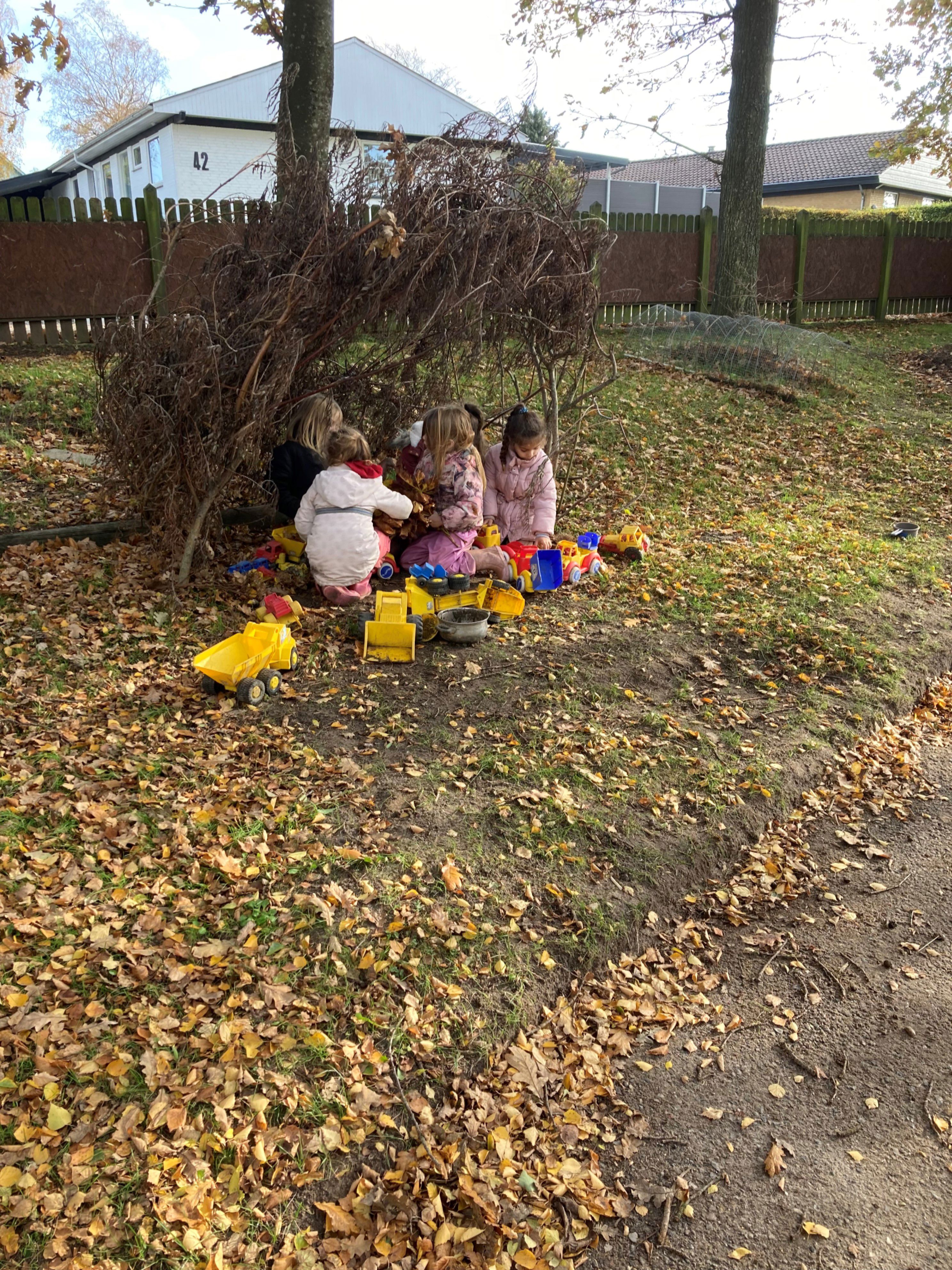Børnehaven leger ude med plastikbiler i Børnehuset Hørhaven